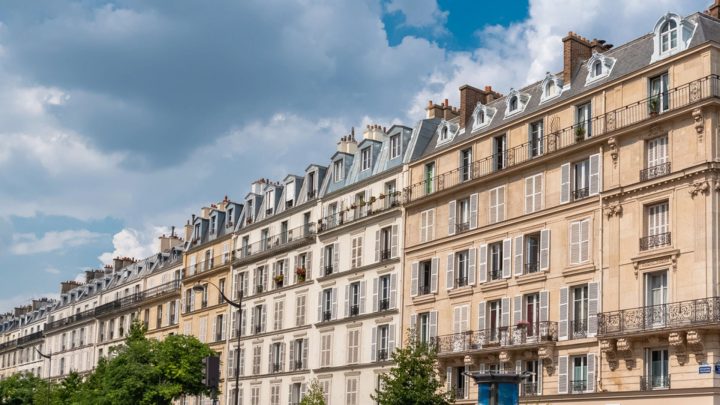 Façades d’immeubles haussmanniens à Paris sous un ciel bleu, illustrant l’optimisation de l’espace dans les petits appartements parisiens.
